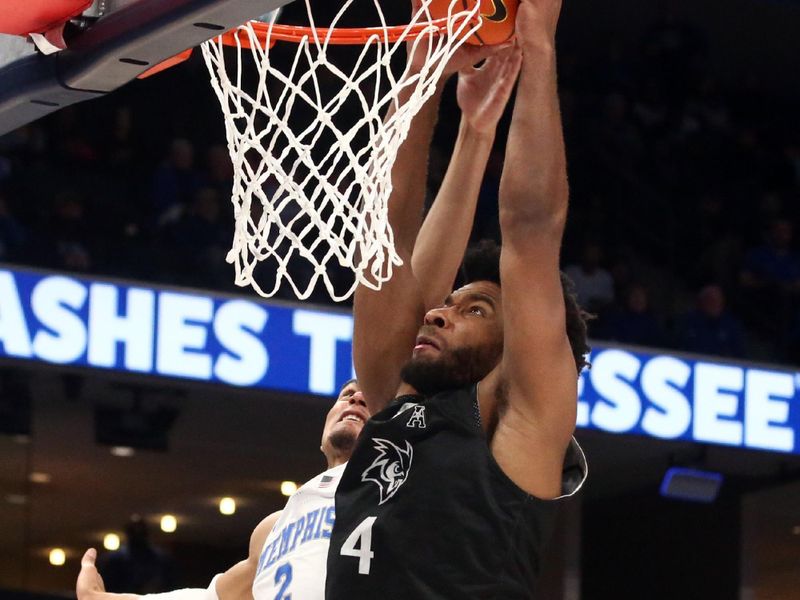 Jan 31, 2024; Memphis, Tennessee, USA; Rice Owls guard Anthony Selden (4) dunks over Memphis Tigers forward Nicholas Jourdain (2) during the second half at FedExForum. Mandatory Credit: Petre Thomas-USA TODAY Sports