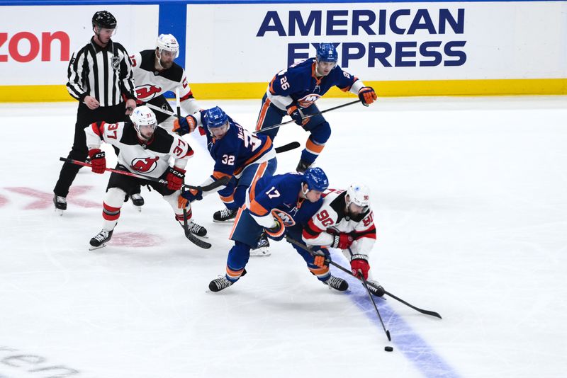 Nov 9, 2024; Elmont, New York, USA; New York Islanders left wing Matt Martin (17) and New Jersey Devils left wing Tomas Tatar (90) compete for the puck during the first period at UBS Arena. Mandatory Credit: John Jones-Imagn Images