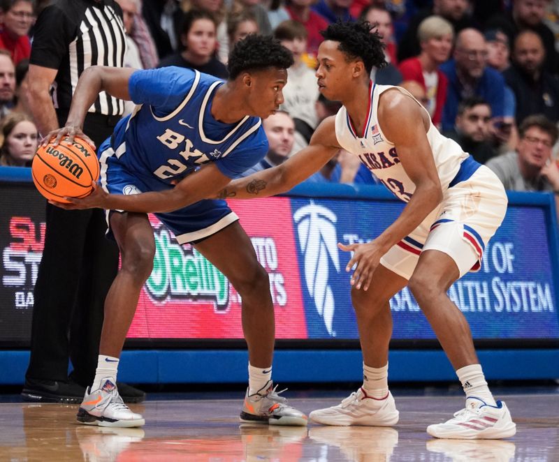 Feb 27, 2024; Lawrence, Kansas, USA; Brigham Young Cougars guard Jaxson Robinson (2) controls the ball as Kansas Jayhawks guard Elmarko Jackson (13) defends during the second half at Allen Fieldhouse. Mandatory Credit: Denny Medley-USA TODAY Sports