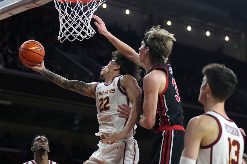 January 14, 2023; Los Angeles, California, USA; Southern California Trojans guard Tre White (22) shoots the ball against Utah Utes center Branden Carlson (35) in the second half at Galen Center. Mandatory Credit: Kirby Lee-USA TODAY Sports