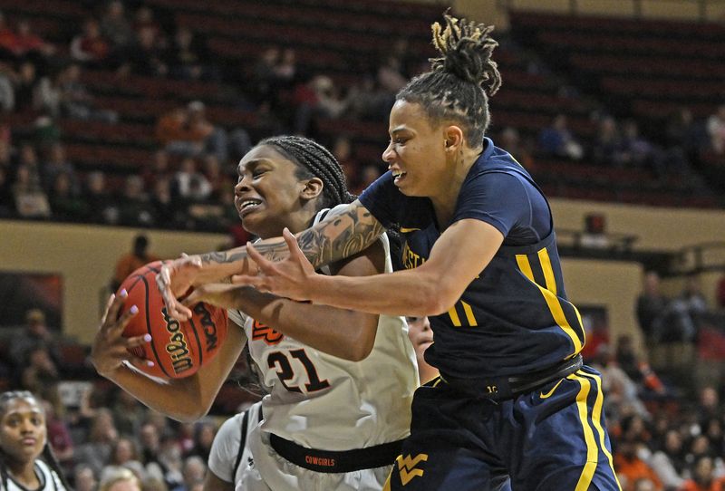 Mar 10, 2023; Kansas City, MO, USA;  Oklahoma State Cowgirls guard Terryn Milton (21) battles for the ball against West Virginia Mountaineers guard JJ Quinerly (11) during the second half at Municipal Auditorium. Mandatory Credit: Peter Aiken-USA TODAY Sports