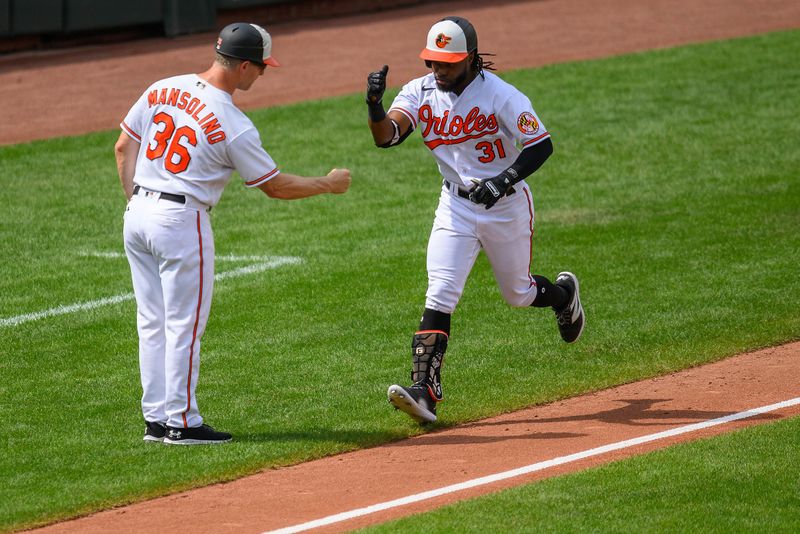 Aug 27, 2023; Baltimore, Maryland, USA; Baltimore Orioles center fielder Cedric Mullins (31) celebrates with Baltimore Orioles third base coach Tony Mansolino (36) after hitting a home run during the fifth inning against against the Colorado Rockies at Oriole Park at Camden Yards. Mandatory Credit: Reggie Hildred-USA TODAY Sports