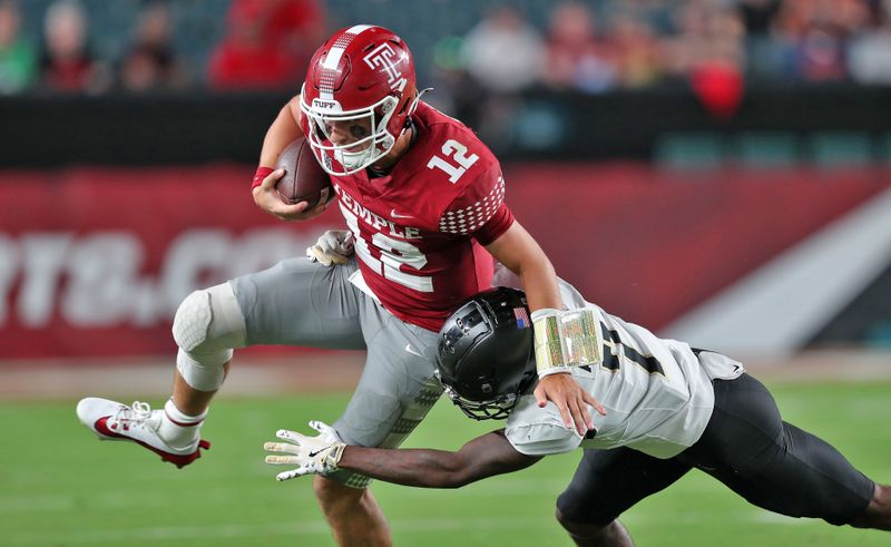 Sep 26, 2024; Philadelphia, Pennsylvania, USA; Temple Owls quarterback Evan Simon (12) is hit by Army Black Knights cornerback Jaydan Mayes (7) during the first half at Lincoln Financial Field. Mandatory Credit: Danny Wild-Imagn Images