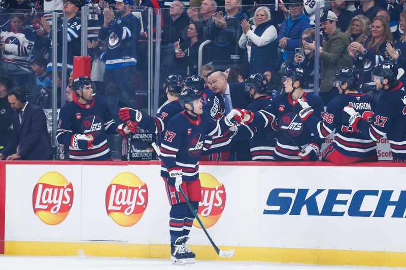 Oct 18, 2024; Winnipeg, Manitoba, CAN;  Winnipeg Jets forward Nikolaj Ehlers (27) is congratulated by his teammates on his goal against the San Jose Sharks during the first period at Canada Life Centre. Mandatory Credit: Terrence Lee-Imagn Images