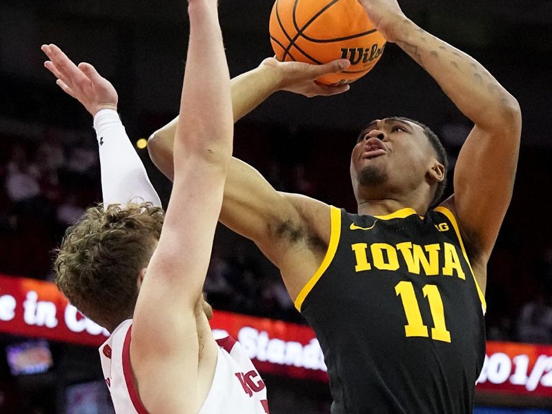 Feb 22, 2023; Madison, Wisconsin, USA; Iowa guard Tony Perkins (11) scores on Wisconsin guard Max Klesmit (11) during the first half at Kohl Center. Mandatory Credit: Mark Hoffman-USA TODAY Sports