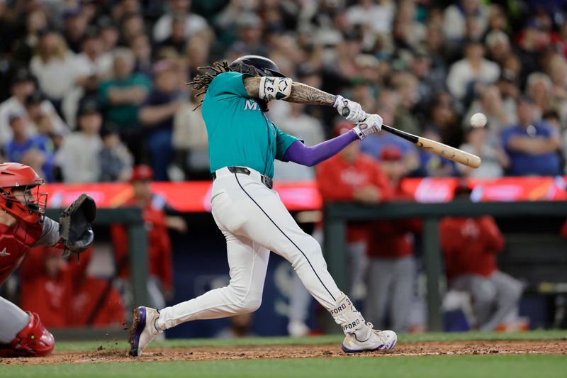 Jun 1, 2024; Seattle, Washington, USA;  Seattle Mariners shortstop J.P. Crawford (3) hits a grand slam against the Los Angeles Angels during the fourth inning at T-Mobile Park. Mandatory Credit: John Froschauer-USA TODAY Sports