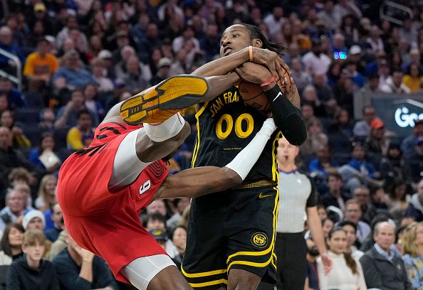 SAN FRANCISCO, CALIFORNIA - DECEMBER 23: Jonathan Kuminga #00 of the Golden State Warriors ties up the ball with Jerami Grant #9 of the Portland Trail Blazers for a jump ball during the first half at Chase Center on December 23, 2023 in San Francisco, California. NOTE TO USER: User expressly acknowledges and agrees that, by downloading and or using this photograph, User is consenting to the terms and conditions of the Getty Images License Agreement. (Photo by Thearon W. Henderson/Getty Images)