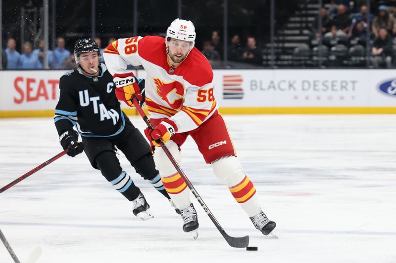 Oct 30, 2024; Salt Lake City, Utah, USA; Calgary Flames center Justin Kirkland (58) skates with the puck against the Utah Hockey Club during the third period at Delta Center. Mandatory Credit: Rob Gray-Imagn Images