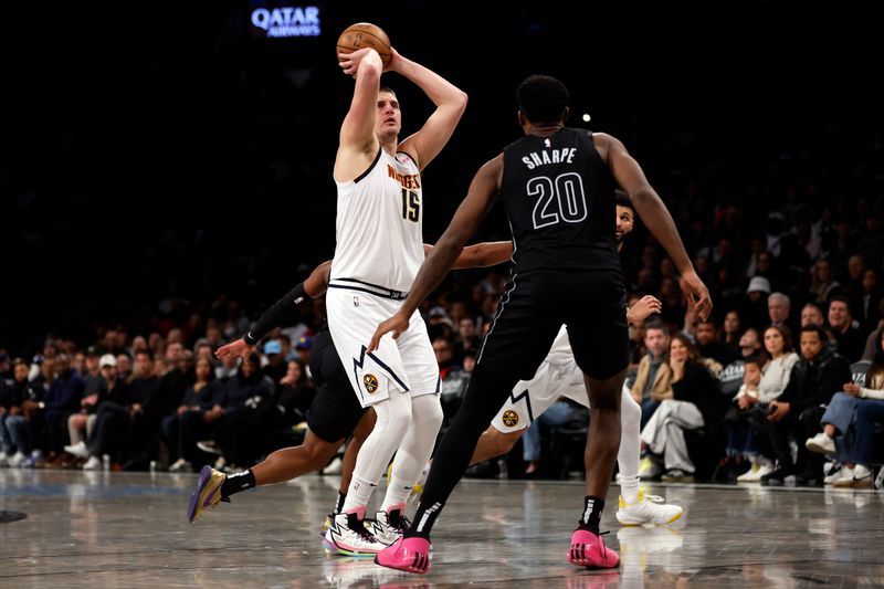 NEW YORK, NEW YORK - DECEMBER 22: Nikola Jokic #15 of the Denver Nuggets shoots the ball as Day'Ron Sharpe #20 of the Brooklyn Nets defends during the second half at Barclays Center on December 22, 2023 in the Brooklyn borough of New York City. The Nuggets won 122-117. NOTE TO USER: User expressly acknowledges and agrees that, by downloading and/or using this Photograph, user is consenting to the terms and conditions of the Getty Images License Agreement. (Photo by Sarah Stier/Getty Images)