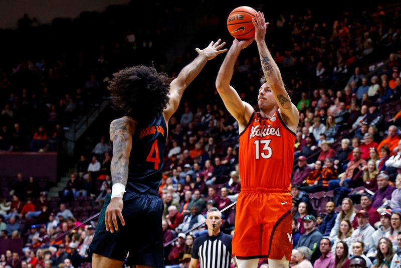 Jan 4, 2025; Blacksburg, Virginia, USA; Virginia Tech Hokies forward Ben Burnham (13) shoots the ball against Miami Hurricanes forward Isaiah Johnson-Arigu (4) during the first half at Cassell Coliseum. Mandatory Credit: Peter Casey-Imagn Images