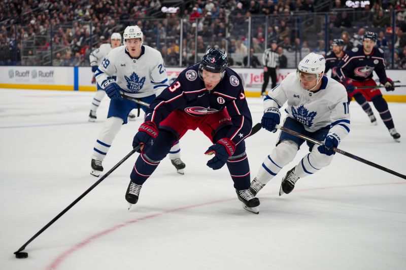 Oct 22, 2024; Columbus, Ohio, USA; Columbus Blue Jackets defenseman Jack Johnson (3) skates with the puck against Toronto Maple Leafs center Max Domi (11) during the second period at Nationwide Arena. Mandatory Credit: Aaron Doster-Imagn Images