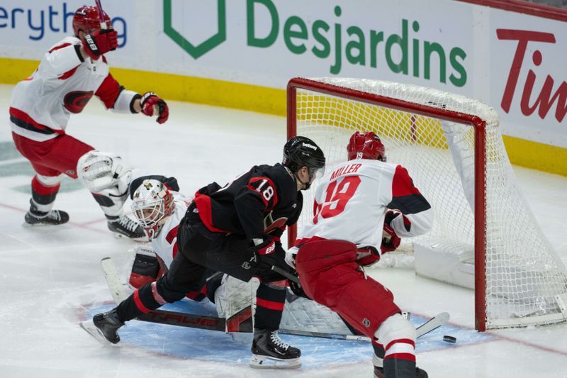 Jan 24, 2026; Ottawa, Ontario, CAN; Carolina Hurricanes defenseman F'Andre Miller (19) clear the puck follow an initial save by goalie Brandon Bussi (32) following a shoty on goal by Ottawa Senators center Tim Stutzle (18) in the third period at the Canadian Tire Centre. Mandatory Credit: Marc DesRosiers-IMAGN Images