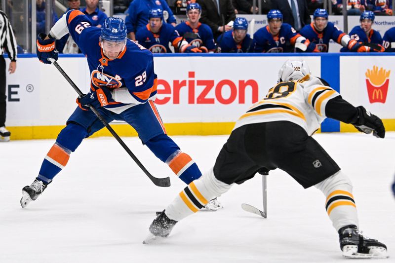 Nov 27, 2024; Elmont, New York, USA;  New York Islanders center Brock Nelson (29) makes a move around Boston Bruins center Elias Lindholm (28) during the second period at UBS Arena. Mandatory Credit: Dennis Schneidler-Imagn Images