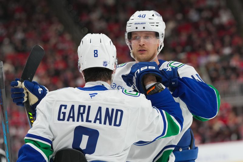 Nov 14, 2025; Raleigh, North Carolina, USA;  Vancouver Canucks right wing Conor Garland (8) celebrates his goal with center Elias Pettersson (40) against the Carolina Hurricanes during the second period at Lenovo Center. Mandatory Credit: James Guillory-Imagn Images