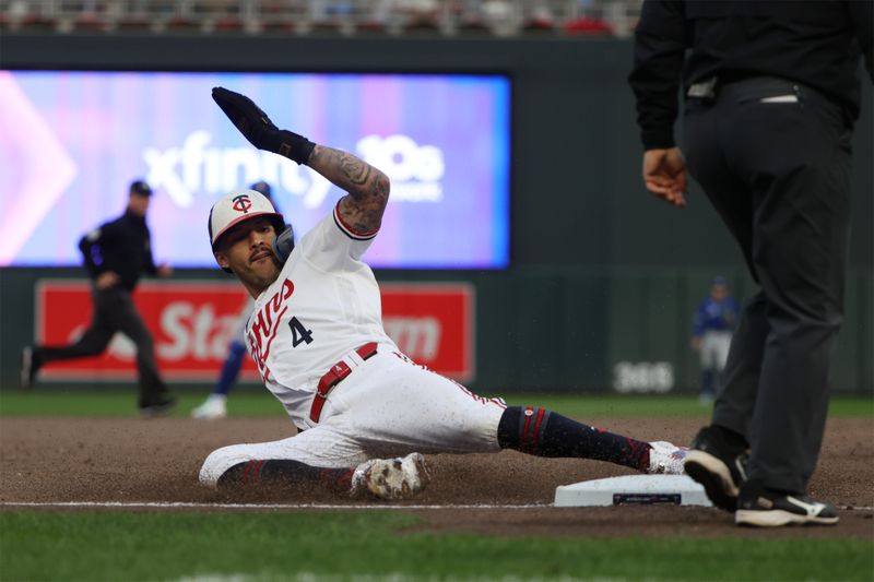 Oct 4, 2023; Minneapolis, Minnesota, USA; Minnesota Twins shortstop Carlos Correa (4) slides into third base in the eighth inning against the Toronto Blue Jays during game two of the Wildcard series for the 2023 MLB playoffs at Target Field. Mandatory Credit: Jesse Johnson-USA TODAY Sports