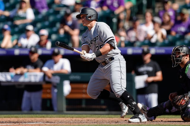 Aug 20, 2023; Denver, Colorado, USA; Chicago White Sox designated hitter Andrew Vaughn (25) hits a single to load the bases in the ninth inning against the Chicago White Sox at Coors Field. Mandatory Credit: Isaiah J. Downing-USA TODAY Sports