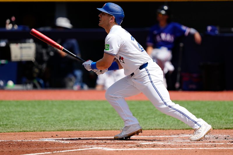 Jul 28, 2024; Toronto, Ontario, CAN; Toronto Blue Jays left fielder Daulton Varsho (25) hits a two run home run against the Texas Rangers during the first inning at Rogers Centre. Mandatory Credit: John E. Sokolowski-USA TODAY Sports