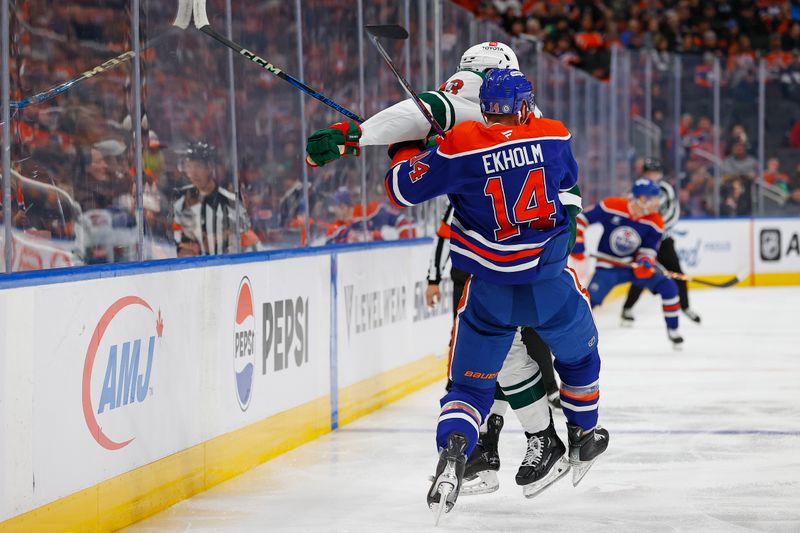 Nov 21, 2024; Edmonton, Alberta, CAN; Minnesota Wild forward Yakov Trenin (13) checks Edmonton Oilers defensemen Mattias Ekholm (14) during the second period at Rogers Place. Mandatory Credit: Perry Nelson-Imagn Images