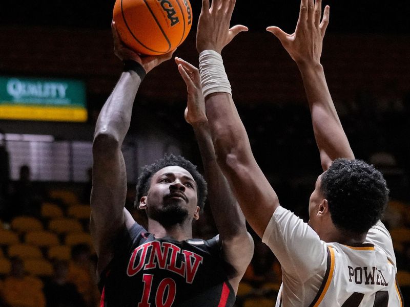 Feb 27, 2024; Laramie, Wyoming, USA; UNLV Runnin' Rebels guard Kalib Boone (10) shoots against Wyoming Cowboys forward Caden Powell (44) during the second half at Arena-Auditorium. Mandatory Credit: Troy Babbitt-USA TODAY Sports