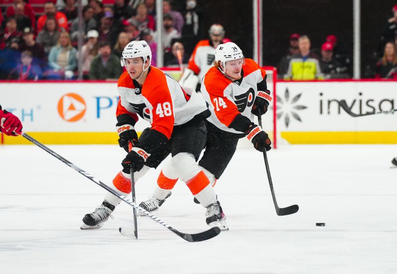 Mar 21, 2024; Raleigh, North Carolina, USA; Philadelphia Flyers right wing Owen Tippett (74) and center Morgan Frost (48) skate with the puck against the Carolina Hurricanes during the second period at PNC Arena. Mandatory Credit: James Guillory-USA TODAY Sports