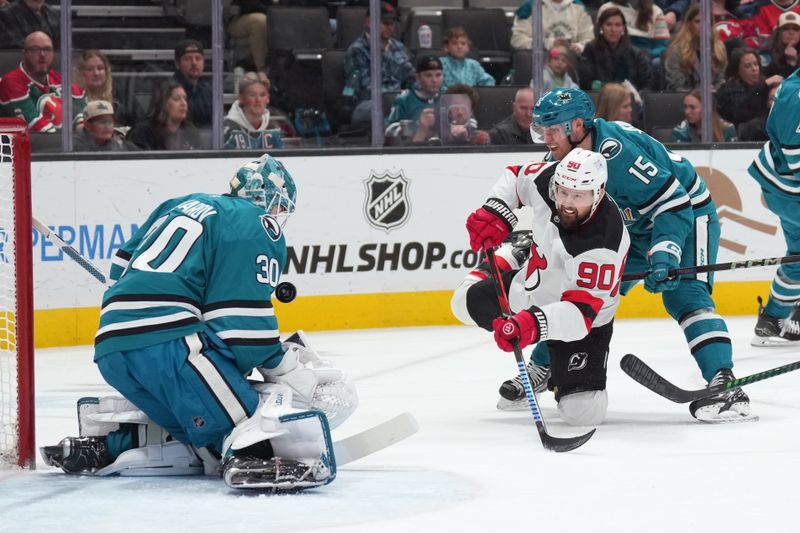 Jan 4, 2025; San Jose, California, USA; New Jersey Devils left wing Tomas Tatar (90) shoots against San Jose Sharks goaltender Yaroslav Askarov (30) and right wing Nikolai Kovalenko (15) during the first period at SAP Center at San Jose. Mandatory Credit: Darren Yamashita-Imagn Images