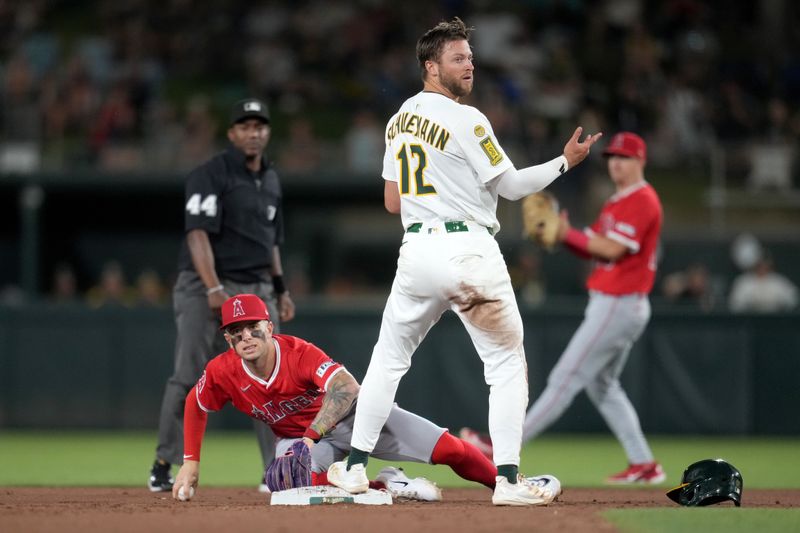 May 21, 2025; West Sacramento, California, USA; Athletics shortstop Max Schuemann (12) reacts after being called out at second base next to Los Angeles Angels shortstop Zach Neto (9) in the fifth inning at Sutter Health Park. Mandatory Credit: Cary Edmondson-Imagn Images