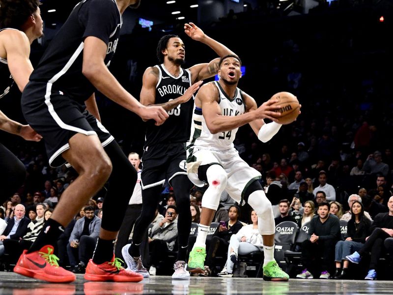 NEW YORK, NEW YORK - DECEMBER 08: Giannis Antetokounmpo #34 of the Milwaukee Bucks is defended by Nic Claxton #33 of the Brooklyn Nets during the first half at Barclays Center on December 08, 2024 in New York City. NOTE TO USER: User expressly acknowledges and agrees that, by downloading and or using this Photograph, user is consenting to the terms and conditions of the Getty Images License Agreement. (Photo by Steven Ryan/Getty Images)