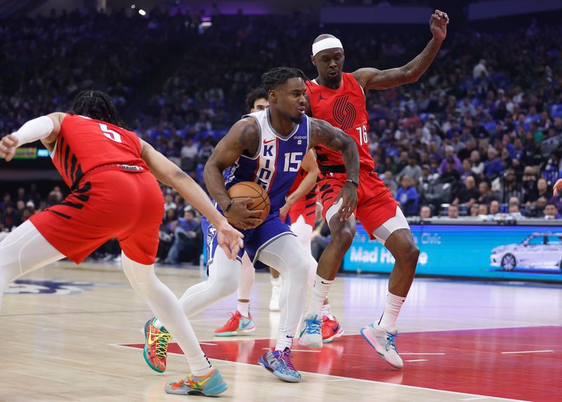 SACRAMENTO, CALIFORNIA - APRIL 14: Davion Mitchell #15 of the Sacramento Kings drives to the basket against Dalano Banton #5 and Taze Moore #76 of the Portland Trail Blazers in the first quarter at Golden 1 Center on April 14, 2024 in Sacramento, California. NOTE TO USER: User expressly acknowledges and agrees that, by downloading and or using this photograph, User is consenting to the terms and conditions of the Getty Images License Agreement. (Photo by Lachlan Cunningham/Getty Images)