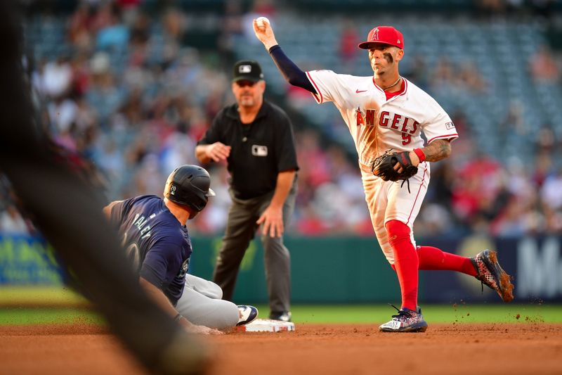 Jul 11, 2024; Anaheim, California, USA; Seattle Mariners right fielder Luke Raley (20) is out at second as Los Angeles Angels shortstop Zach Neto (9) throws to first for the out against second baseman Jorge Polanco (7) during the third inning at Angel Stadium. Mandatory Credit: Gary A. Vasquez-USA TODAY Sports