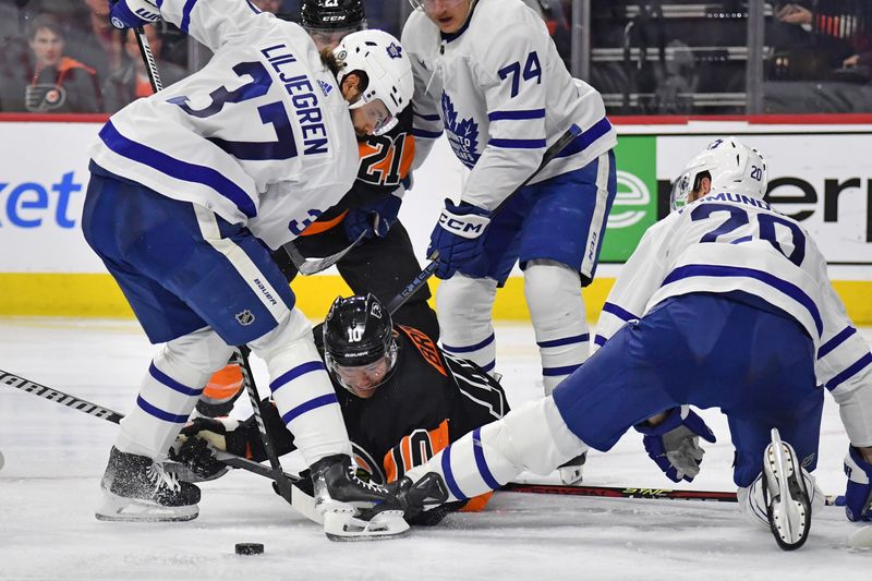 Mar 19, 2024; Philadelphia, Pennsylvania, USA; Philadelphia Flyers right wing Bobby Brink (10) battle for the puck against Toronto Maple Leafs defenseman Timothy Liljegren (37) and defenseman Joel Edmundson (20) during the third period at Wells Fargo Center. Mandatory Credit: Eric Hartline-USA TODAY Sports