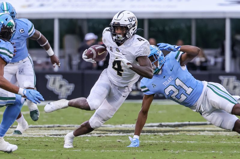 Nov 6, 2021; Orlando, Florida, USA; UCF Knights wide receiver Ryan O'Keefe (4) runs the ball against Tulane Green Wave defensive back Ajani Kerr (21) during the second quarter at Bounce House. Mandatory Credit: Mike Watters-USA TODAY Sports