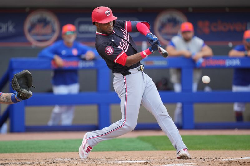 Mar 24, 2024; Port St. Lucie, Florida, USA;  Washington Nationals center fielder Victor Robles (16) hits an infield single in the third inning against the New York Mets at Clover Park. Mandatory Credit: Jim Rassol-USA TODAY Sports