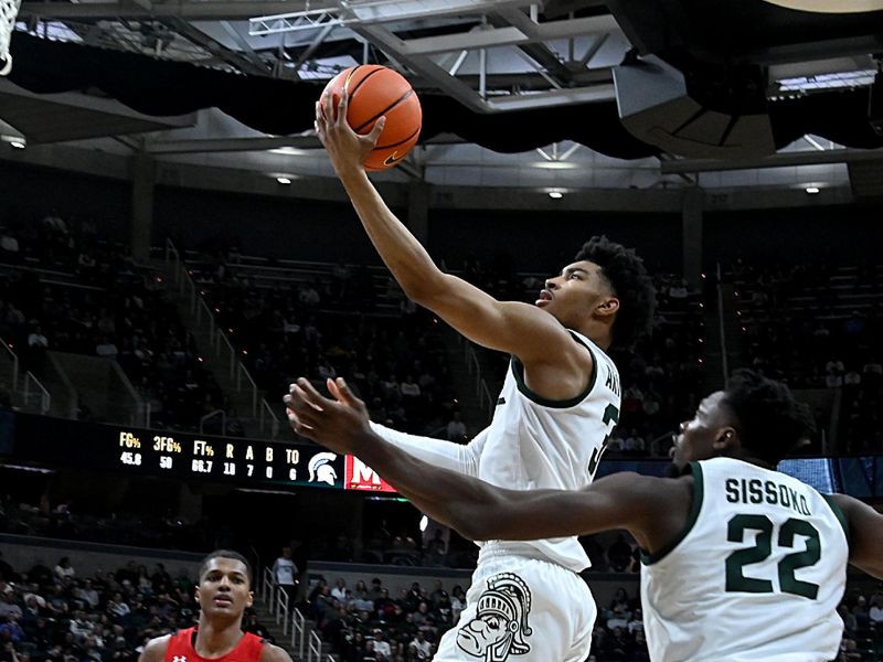 Feb 7, 2023; East Lansing, Michigan, USA;  Michigan State Spartans guard Jaden Akins (3) drives in for a basket as center Mady Sissoko (22) and Maryland Terrapins forward Julian Reese (10) watch in the second half at Jack Breslin Student Events Center. Mandatory Credit: Dale Young-USA TODAY Sports