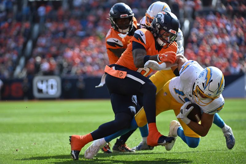 Los Angeles Chargers wide receiver Ladd McConkey (15) is tackled during the first half of an NFL football game against the Denver Broncos, Sunday, Oct. 13, 2024, in Denver. (AP Photo/Geneva Heffernan)