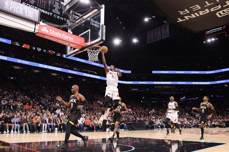 PHOENIX, ARIZONA - JANUARY 06: Jimmy Butler #22 of the Miami Heat lays up a shot over Chris Paul #3 of the Phoenix Suns during the first half of the NBA game at Footprint Center on January 06, 2023 in Phoenix, Arizona. NOTE TO USER: User expressly acknowledges and agrees that, by downloading and or using this photograph, User is consenting to the terms and conditions of the Getty Images License Agreement. (Photo by Christian Petersen/Getty Images)