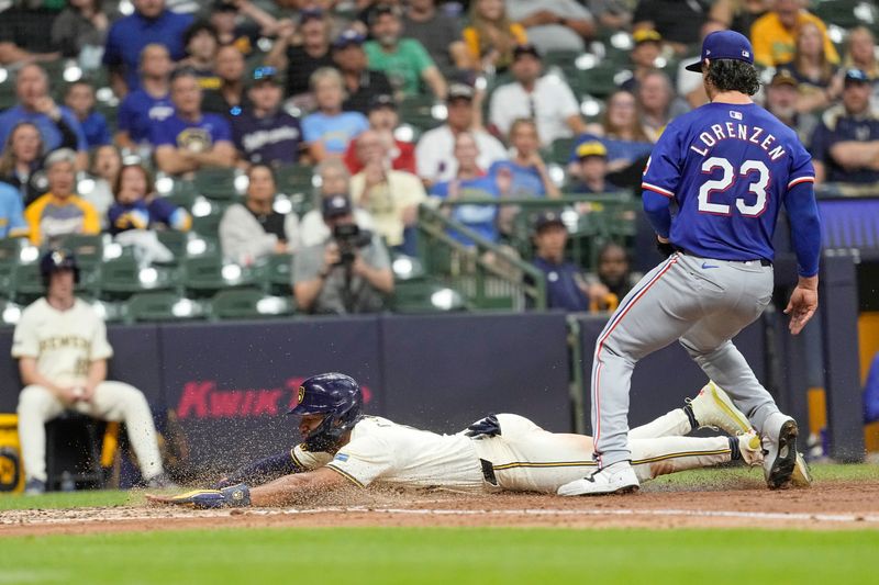 Jun 24, 2024; Milwaukee, Wisconsin, USA;  Milwaukee Brewers right fielder Jackson Chourio (11) slides into home plate to score a run behind jTexas Rangers pitcher Michael Lorenzen (23) during the fifth inning at American Family Field. Mandatory Credit: Jeff Hanisch-USA TODAY Sports