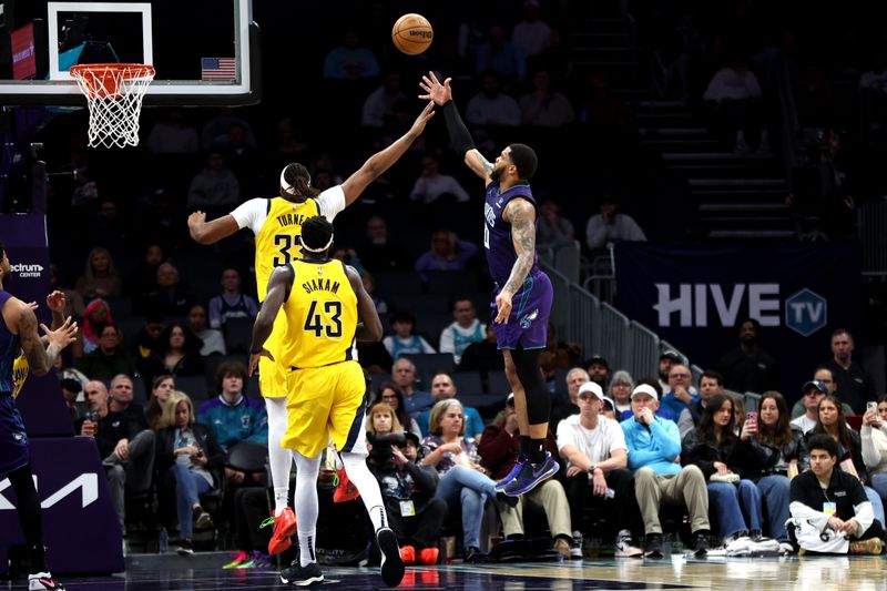 CHARLOTTE, NORTH CAROLINA - FEBRUARY 12: Miles Bridges #0 of the Charlotte Hornets lays the ball up over Myles Turner #33 of the Indiana Pacers during the second half of an NBA game at Spectrum Center on February 12, 2024 in Charlotte, North Carolina. NOTE TO USER: User expressly acknowledges and agrees that, by downloading and or using this photograph, User is consenting to the terms and conditions of the Getty Images License Agreement. (Photo by David Jensen/Getty Images)