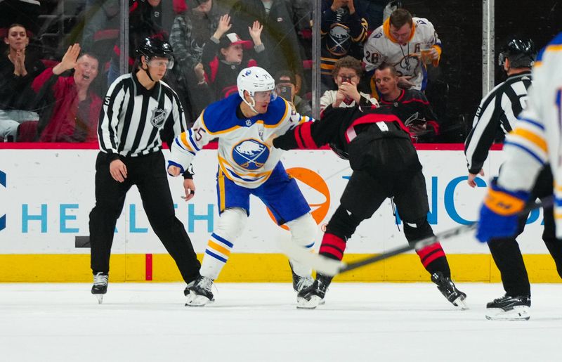 Dec 2, 2023; Raleigh, North Carolina, USA; Carolina Hurricanes center Jack Drury (18) and Buffalo Sabres defenseman Connor Clifton (75) fight during the third period at PNC Arena. Mandatory Credit: James Guillory-USA TODAY Sports