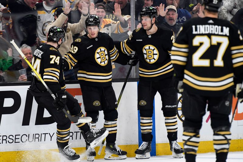 Mar 16, 2024; Boston, Massachusetts, USA; Boston Bruins center Morgan Geekie (39) is congratulated by left wing Jake DeBrusk (74) and defenseman Brandon Carlo (25) after scoring a goal during the first period against the Philadelphia Flyers at TD Garden. Mandatory Credit: Bob DeChiara-USA TODAY Sports