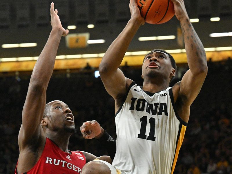 Jan 6, 2024; Iowa City, Iowa, USA; Iowa Hawkeyes guard Tony Perkins (11) goes to the basket as Rutgers Scarlet Knights forward Aundre Hyatt (5) defends during the second half at Carver-Hawkeye Arena. Mandatory Credit: Jeffrey Becker-USA TODAY Sports