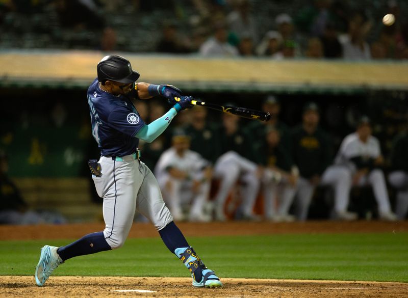 Jun 5, 2024; Oakland, California, USA; Seattle Mariners center fielder Julio Rodríguez (44) connects for a solo home run against the Oakland Athletics during the ninth inning at Oakland-Alameda County Coliseum. Mandatory Credit: D. Ross Cameron-USA TODAY Sports