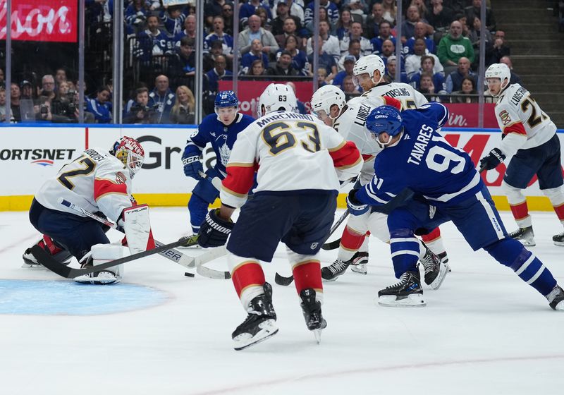May 7, 2025; Toronto, Ontario, CAN; Toronto Maple Leafs center John Tavares (91) battles for the puck with Florida Panthers center Anton Lundell (15) during the third period in game two of the second round of the 2025 Stanley Cup Playoffs at Scotiabank Arena. Mandatory Credit: Nick Turchiaro-Imagn Images