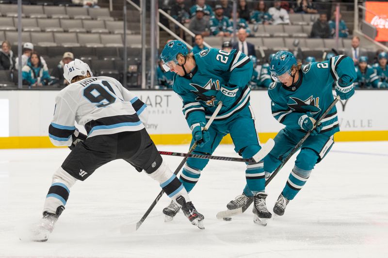 Oct 1, 2024; San Jose, California, USA;  San Jose Sharks left wing Fabian Zetterlund (20) and center Will Smith (2) reach for the puck against Utah Hockey Club forward Josh Down (91) during the first period  at SAP Center at San Jose. Mandatory Credit: Stan Szeto-Imagn Images
