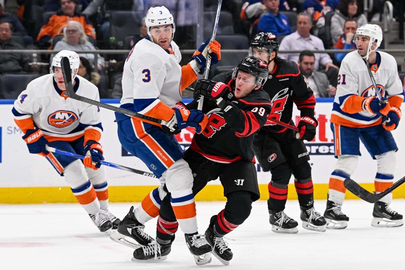 Mar 19, 2024; Elmont, New York, USA; New York Islanders defenseman Adam Pelech (3) and Carolina Hurricanes left wing Jake Guentzel (59) collide during the third period at UBS Arena. Mandatory Credit: Dennis Schneidler-USA TODAY Sports