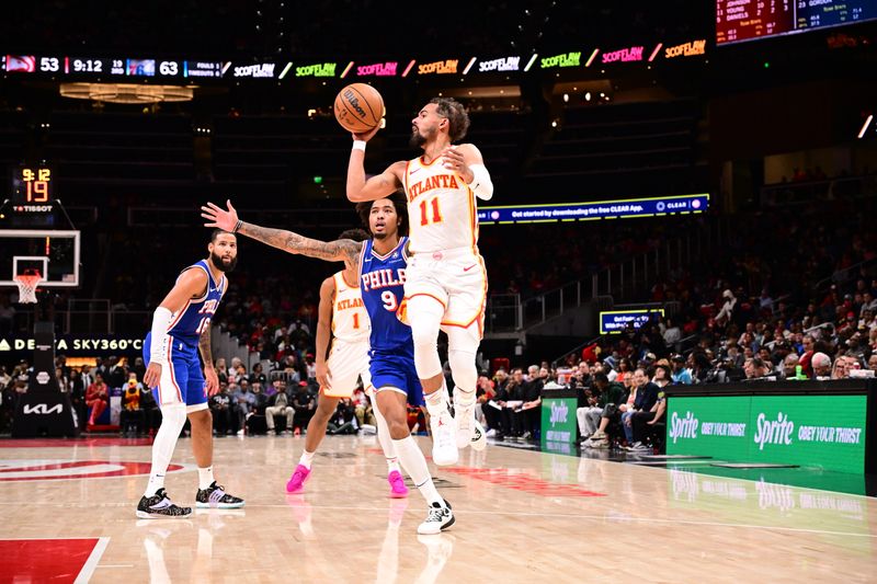 ATLANTA, GA - OCTOBER 14:  Trae Young #11 of the Atlanta Hawks looks to pass the ball during the game against the Philadelphia 76ers during a preseason game on October 14, 2024 at State Farm Arena in Atlanta, Georgia.  NOTE TO USER: User expressly acknowledges and agrees that, by downloading and/or using this Photograph, user is consenting to the terms and conditions of the Getty Images License Agreement. Mandatory Copyright Notice: Copyright 2024 NBAE (Photo by Adam Hagy/NBAE via Getty Images)