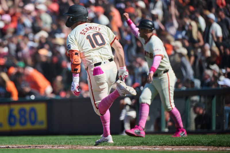 May 12, 2024; San Francisco, California, USA; San Francisco Giants first base coach Mark Hallberg (91) celebrates as infielder Casey Schmitt (10) rounds first base with a walk-off RBI single against the Cincinnati Reds during the tenth inning at Oracle Park. Mandatory Credit: Robert Edwards-USA TODAY Sports