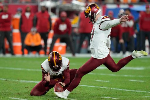 Washington Commanders place kicker Zane Gonzalez, right, kicks the game winning field goal from the hold of Tress Way during the second half of an NFL wild-card playoff football game against the Tampa Bay Buccaneers in Tampa, Fla., Sunday, Jan. 12, 2025. (AP Photo/Chris O'Meara)