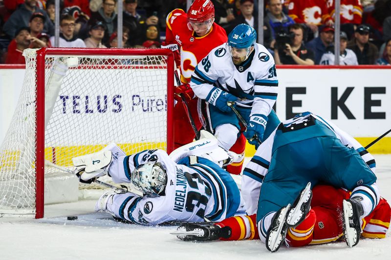 Jan 31, 2026; Calgary, Alberta, CAN; San Jose Sharks goaltender Alex Nedeljkovic (33) makes a save against Calgary Flames right wing Matt Coronato (27) during the second period at Scotiabank Saddledome. Mandatory Credit: Sergei Belski-Imagn Images