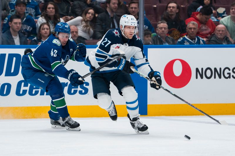 Mar 18, 2025; Vancouver, British Columbia, CAN; Vancouver Canucks defenseman Quinn Hughes (43) stick checks Winnipeg Jets forward Nikolaj Ehlers (27) in the first period at Rogers Arena. Mandatory Credit: Bob Frid-Imagn Images