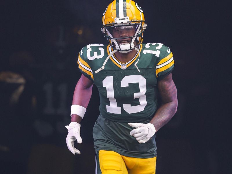 Green Bay Packers wide receiver Dontayvion Wicks (13) during introductions before the first half of a NFL football game against the New Orleans Saints Sunday, Sept. 24, 2023, in Green Bay, Wis. (AP Photo/Jeffrey Phelps)